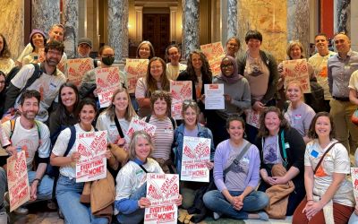 Members of the Minnesota Families for Public Schools standing together in the rotunda of the Minnesota State Capital holding signs supporting funding for Public Schools.