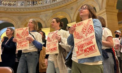 Members of the Minnesota Families for Public Schools standing together in the rotunda of the Minnesota State Capital holding signs supporting funding for Public Schools.