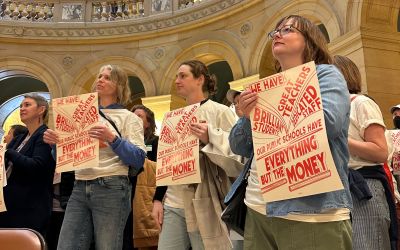 Members of the Minnesota Families for Public Schools standing together in the rotunda of the Minnesota State Capital holding signs supporting funding for Public Schools.