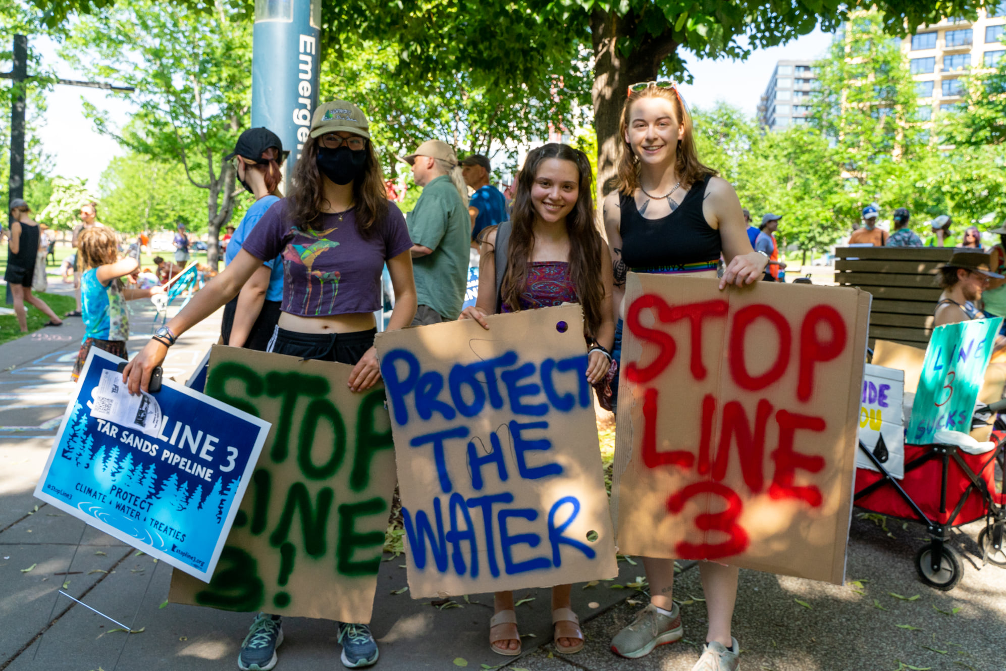Protesters hold signs at June 10, 2021 Line 3 event in Minneapolis