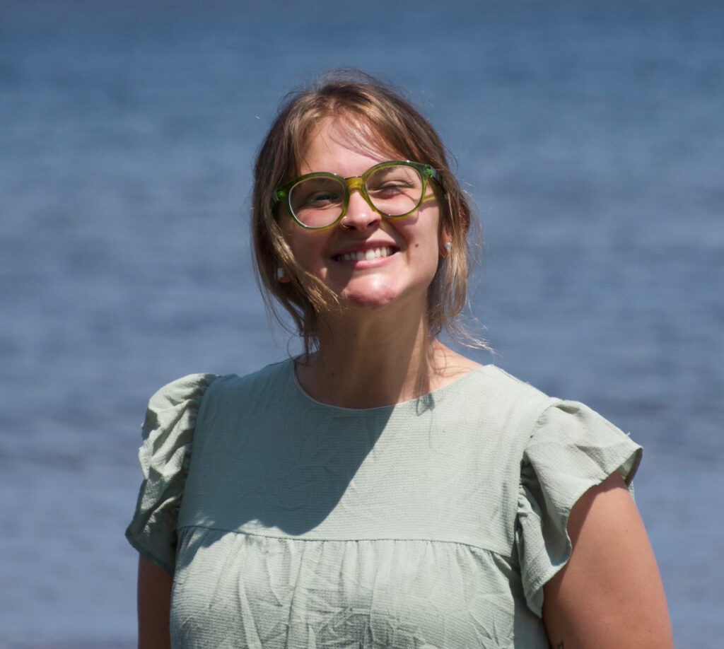 DyAnna Grondahl smiles at the camera from the shores of Lake Superior. 